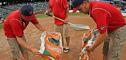 Auburn turfgrass management major Jared Nash, right, and co-workers disperse a drying agent on the field at Rangers Ballpark in Arlington following a heavy rain that fell a couple of hours before a Texas Rangers baseball game.