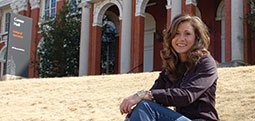 Lauren Terry posing on the front lawn of Comer Hall with her cowboy boot collection